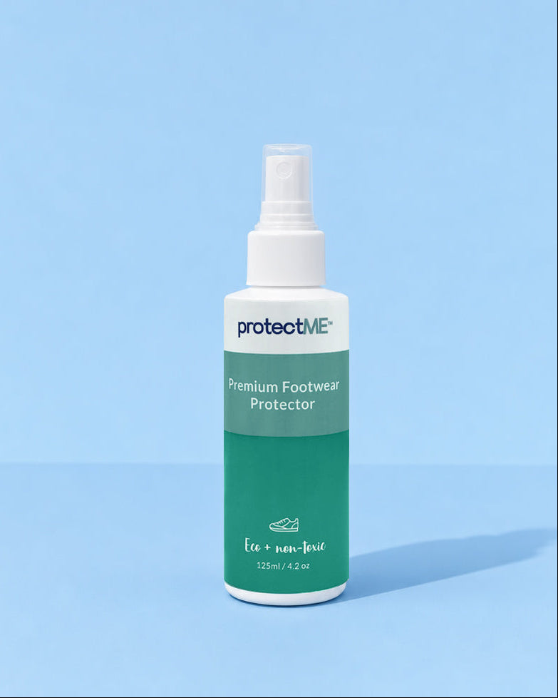 A 125ml spray bottle of protectME Premium Footwear Protector, featuring a white upper and a green lower label, set against a solid light blue background.